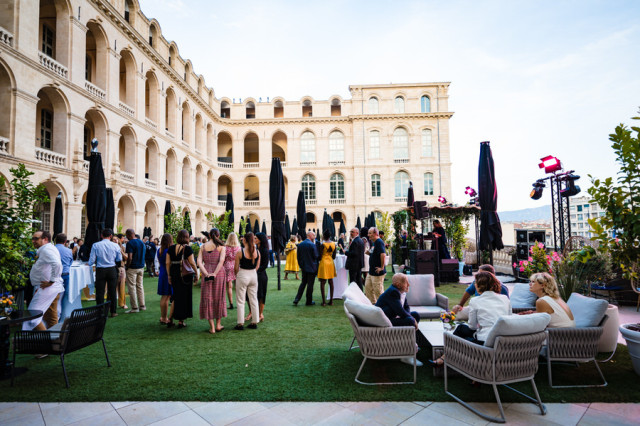 Invités échangeant lors de la réception en plein air dans la cour de l'InterContinental Marseille. Reportage événementiel par Gilles Perbal.