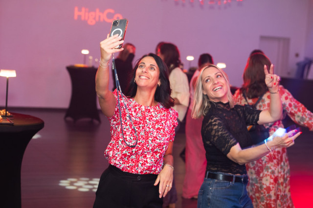 Deux invitées s'amusant à prendre un selfie sur la piste de danse pendant l'événementiel corporate.