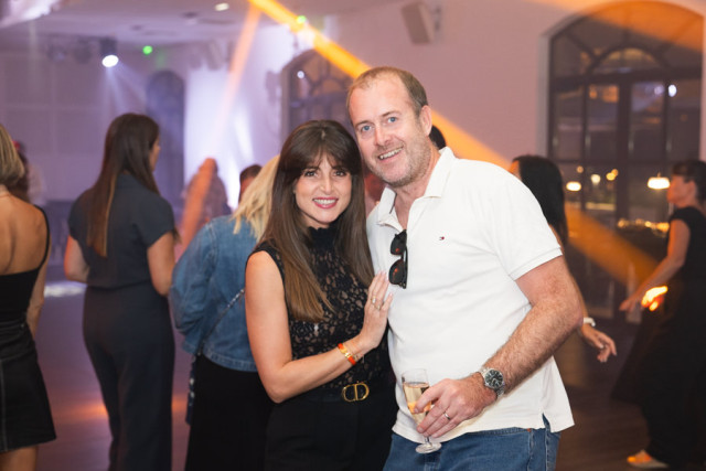 Un homme et une femme souriants posant sur la piste de danse lors de la soirée d'entreprise au Château de Saint Hilaire.