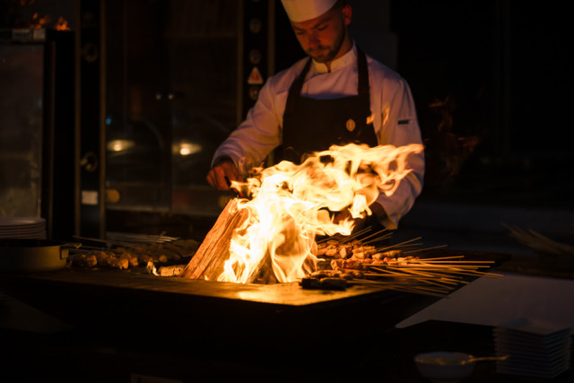 Impressionnante cuisson à la flamme sur un grand brasero pour le dîner de la soirée événementielle à Marseille.