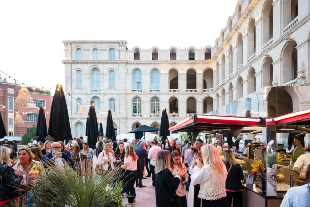Invités échangeant lors du cocktail de networking en fin de journée sur la grande terrasse de l'Hôtel-Dieu.