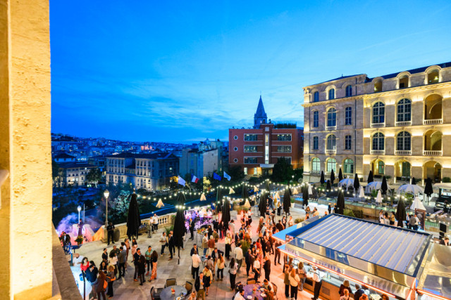 Ambiance du cocktail de rentrée avec de nombreux collaborateurs réunis sur l'esplanade surplombant le Vieux-Port.