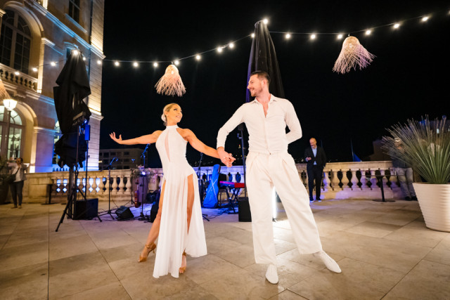 Duo de danseurs contemporains en tenue blanche réalisant une performance artistique lors du cocktail marseillais.