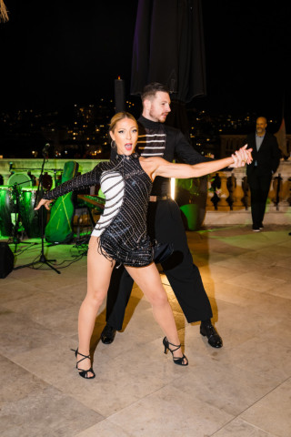 Danseuse en robe à paillettes noires réalisant une chorégraphie dynamique devant le public de l'entreprise.
