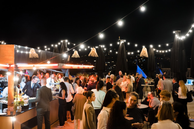 Ambiance chaleureuse de nuit sous des guirlandes lumineuses type guinguette pendant le dîner corporate.