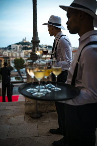 Détail du service traiteur de luxe avec un serveur apportant les rafraîchissements lors du rassemblement BtoB.